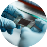 Closeup of gloved hands examining a computer chip